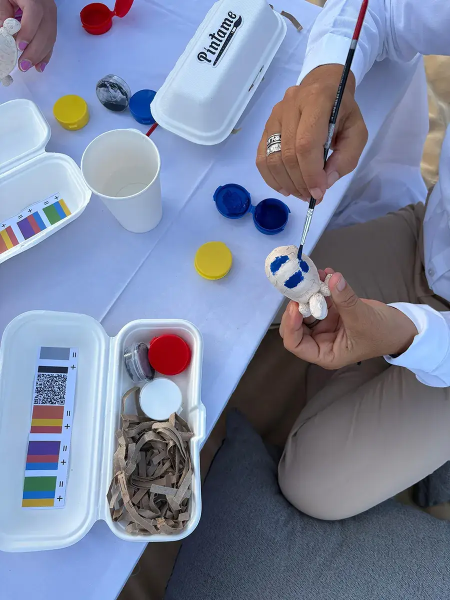 Hands painting a small ceramic figure