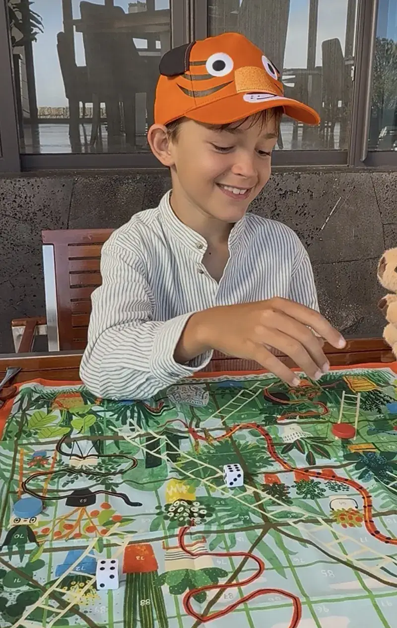 A young guest playing a board game at Pikaia Lodge