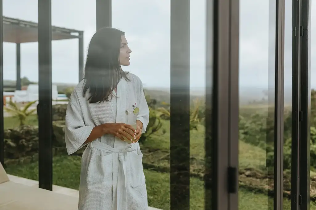 Guest in a spa robe looking out from Sumaq Spa