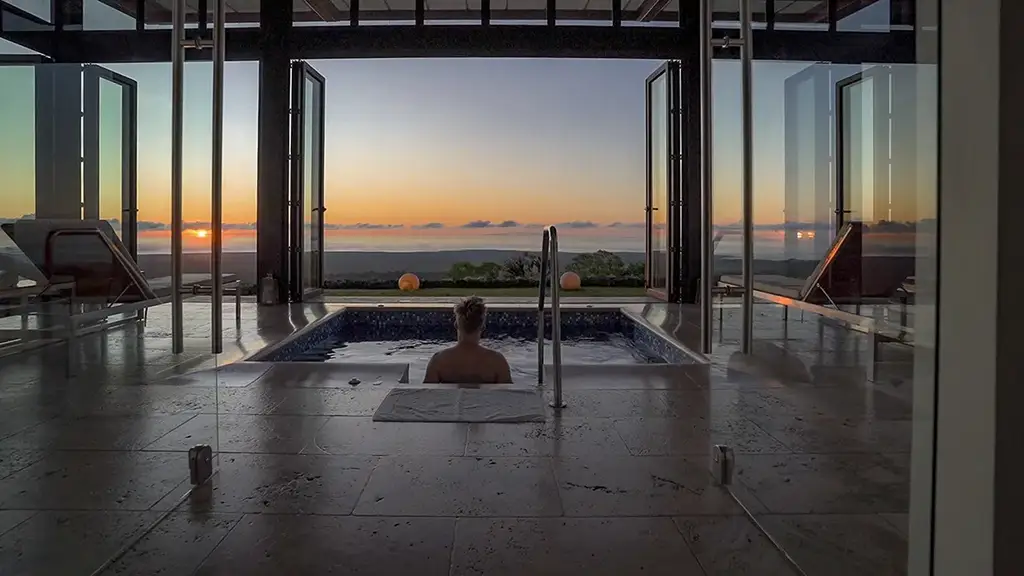 Guest relaxing in the spa pool at sunset